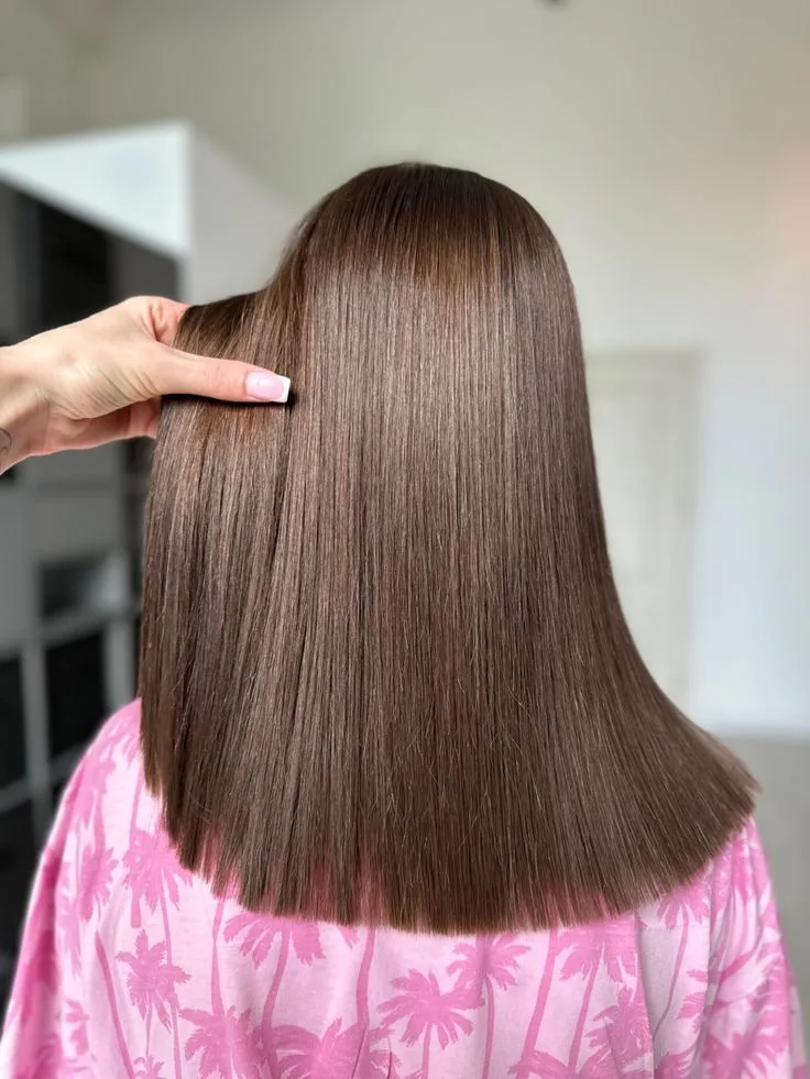Smooth, straight hair being gently held to show shine and texture.